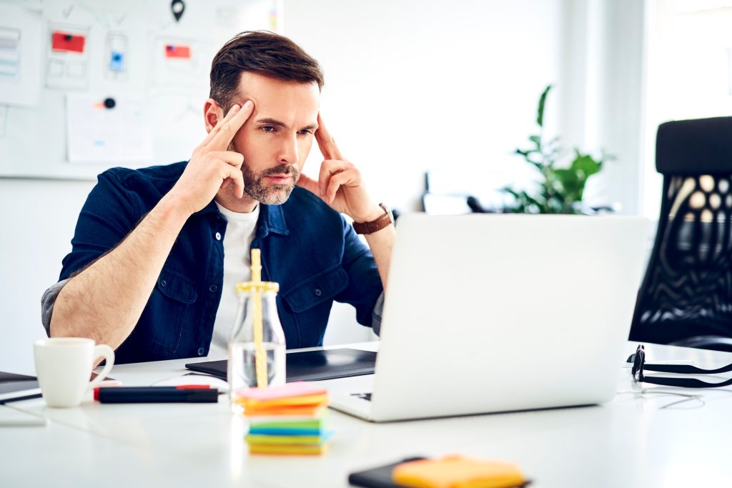Focused businessman working on laptop at desk in office