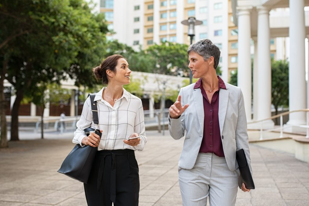 Mature business women in conversation while walking